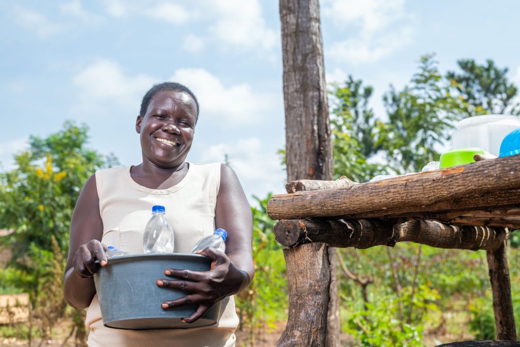 A happy lady carries SODIS bottles