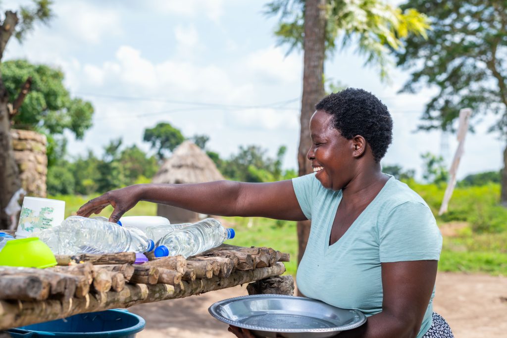 A lady placing SODIS bottles onto a rack