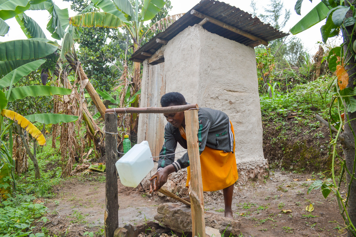 Midius washing her hands using a tippy tap