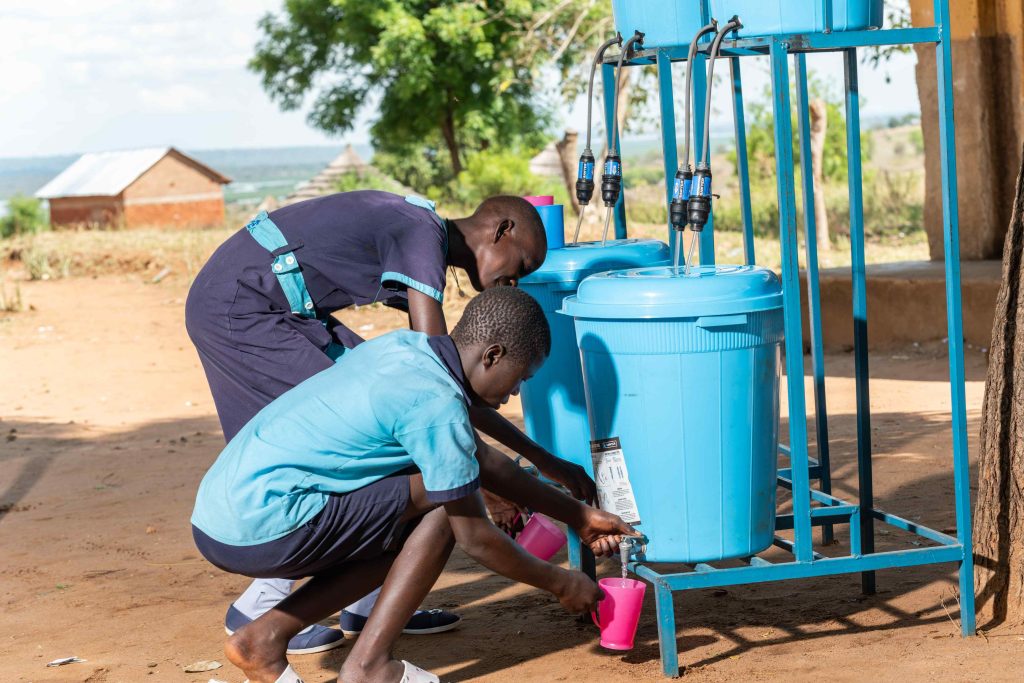 Students drawing water from a Sawyer filter