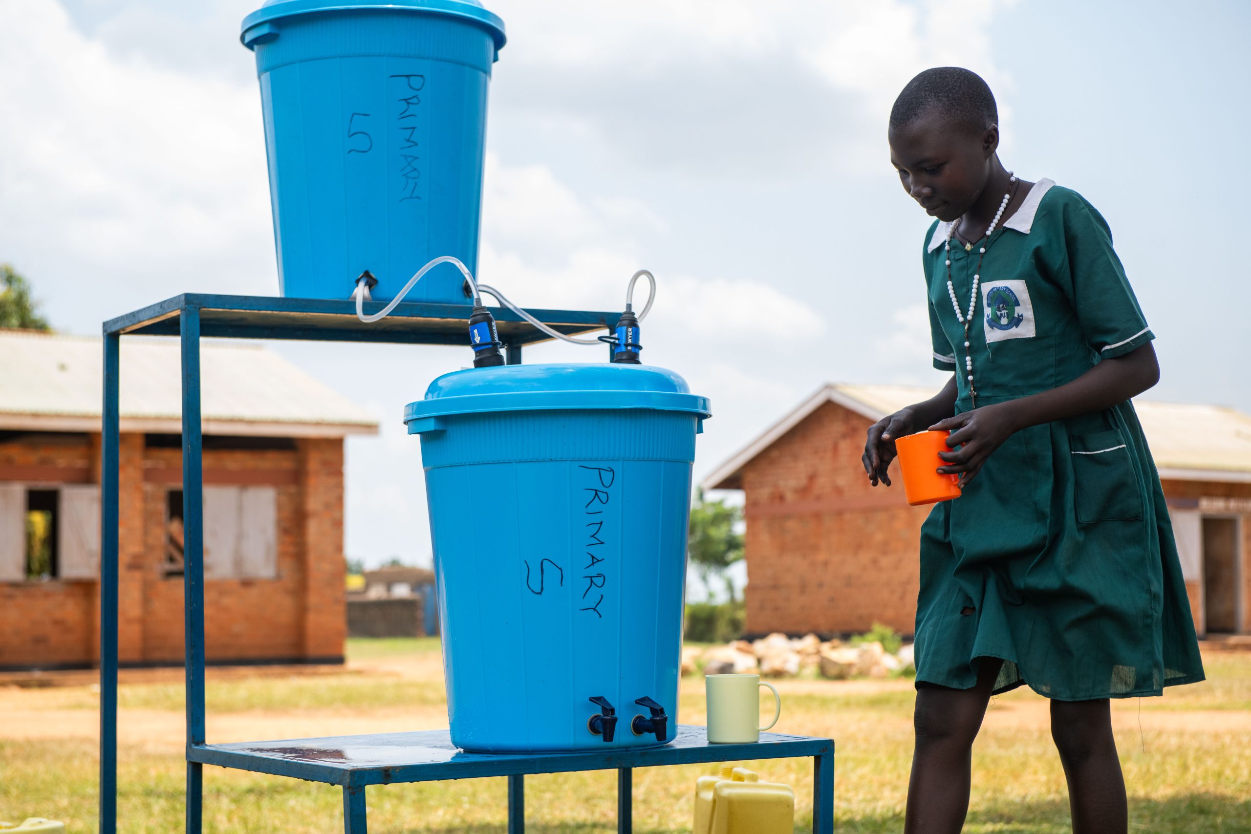 A girl walking towards a SAWYER filter system