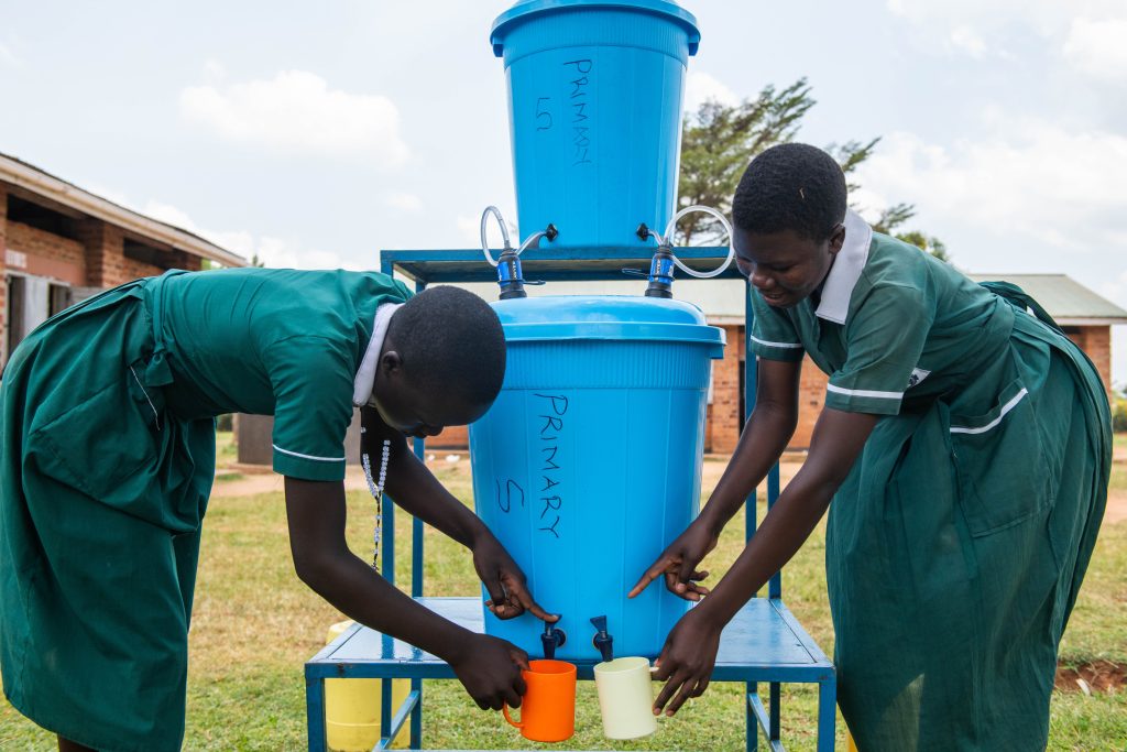 Two Girls drawing water from a sawyer filter