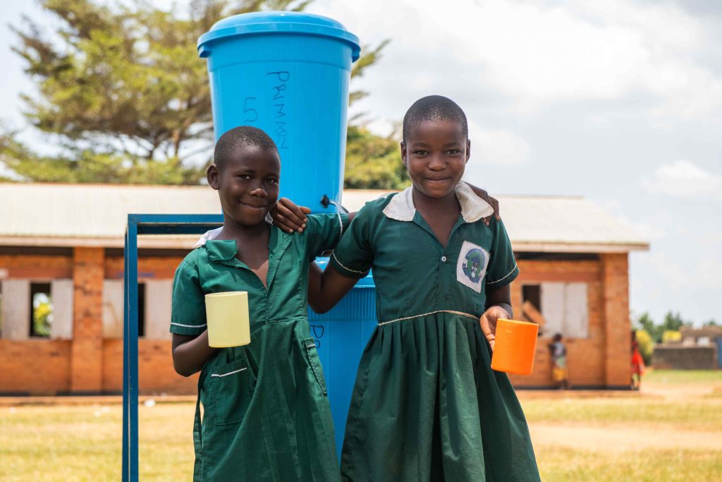 Two girls standing infront of a Sawyer filter