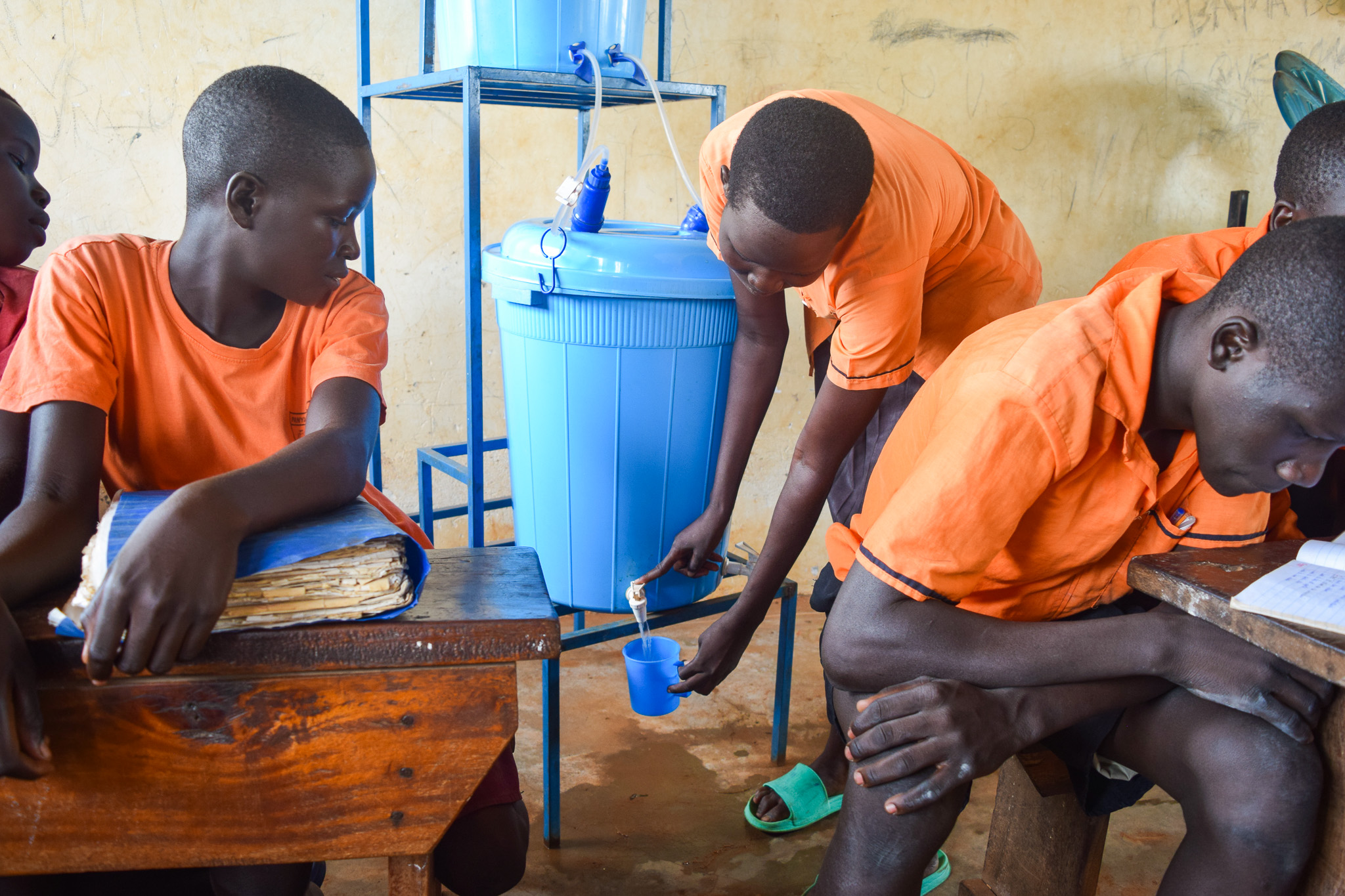 A student of Japiemonen primary school draws water from a SAWYER filter