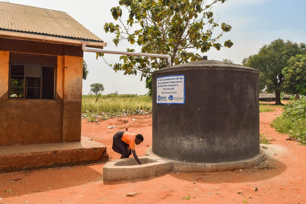 A Japiemonen student fetches water from a rainwater harvesting tank
