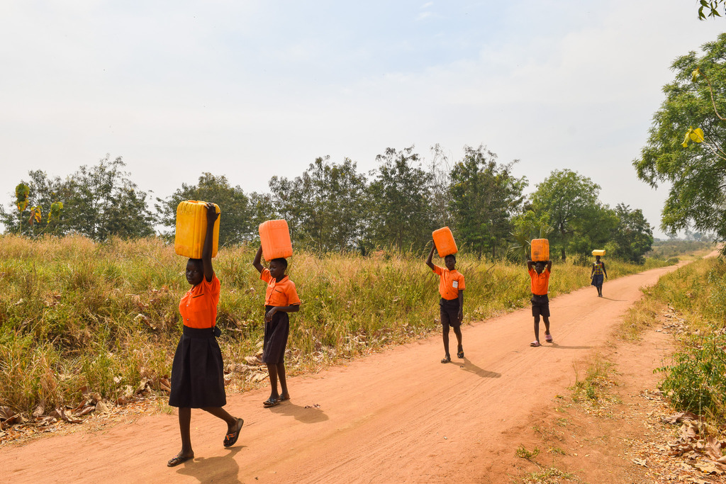 Japiemonen students carrying water jerrycans on their heads