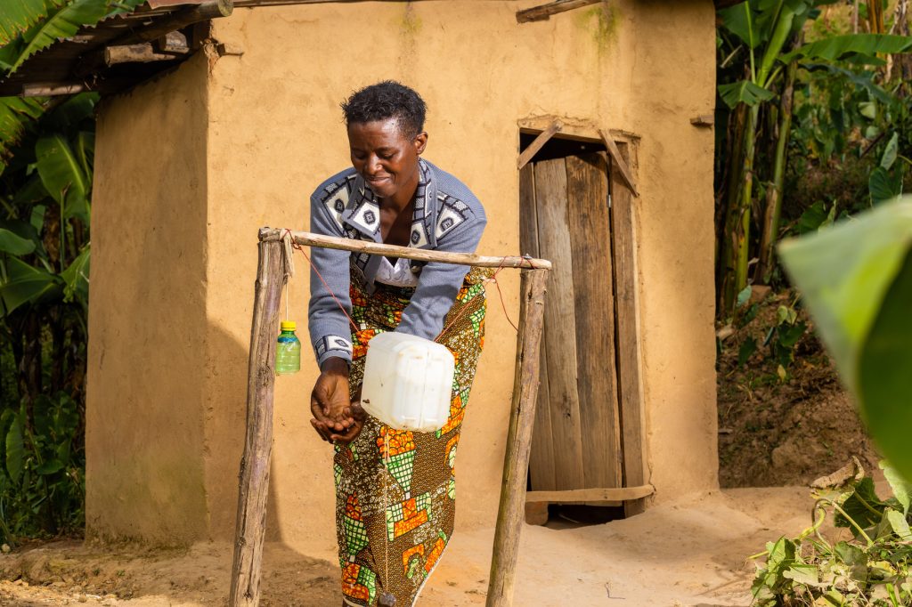 Emmanuel's wife using a tippy tap