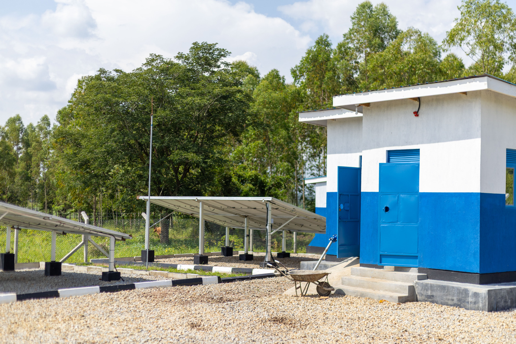 A photo of the Nabuyoga solar motorised borehole water system showing the pump station and the solar panels